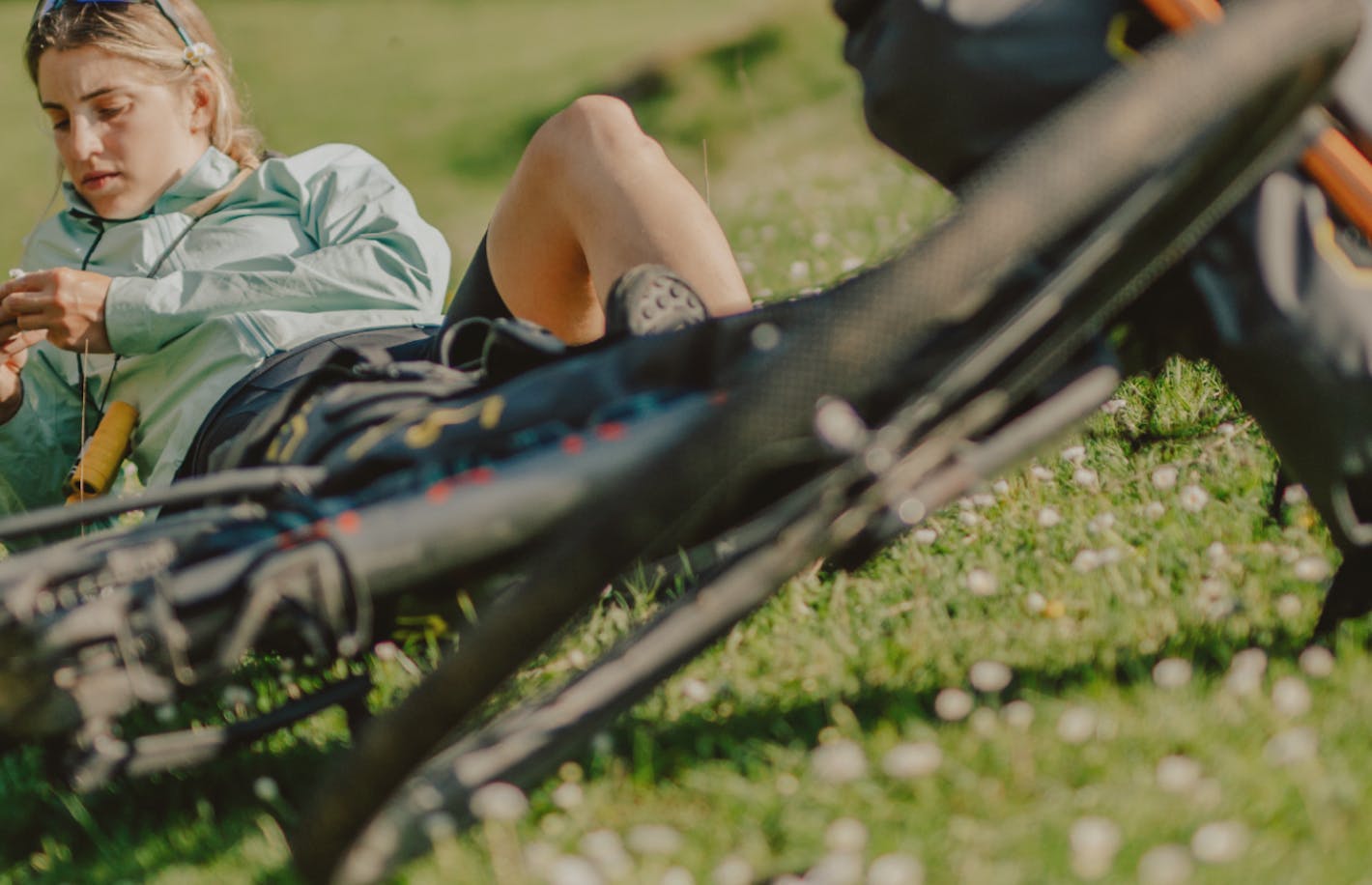 Woman sitting in a field with her bike