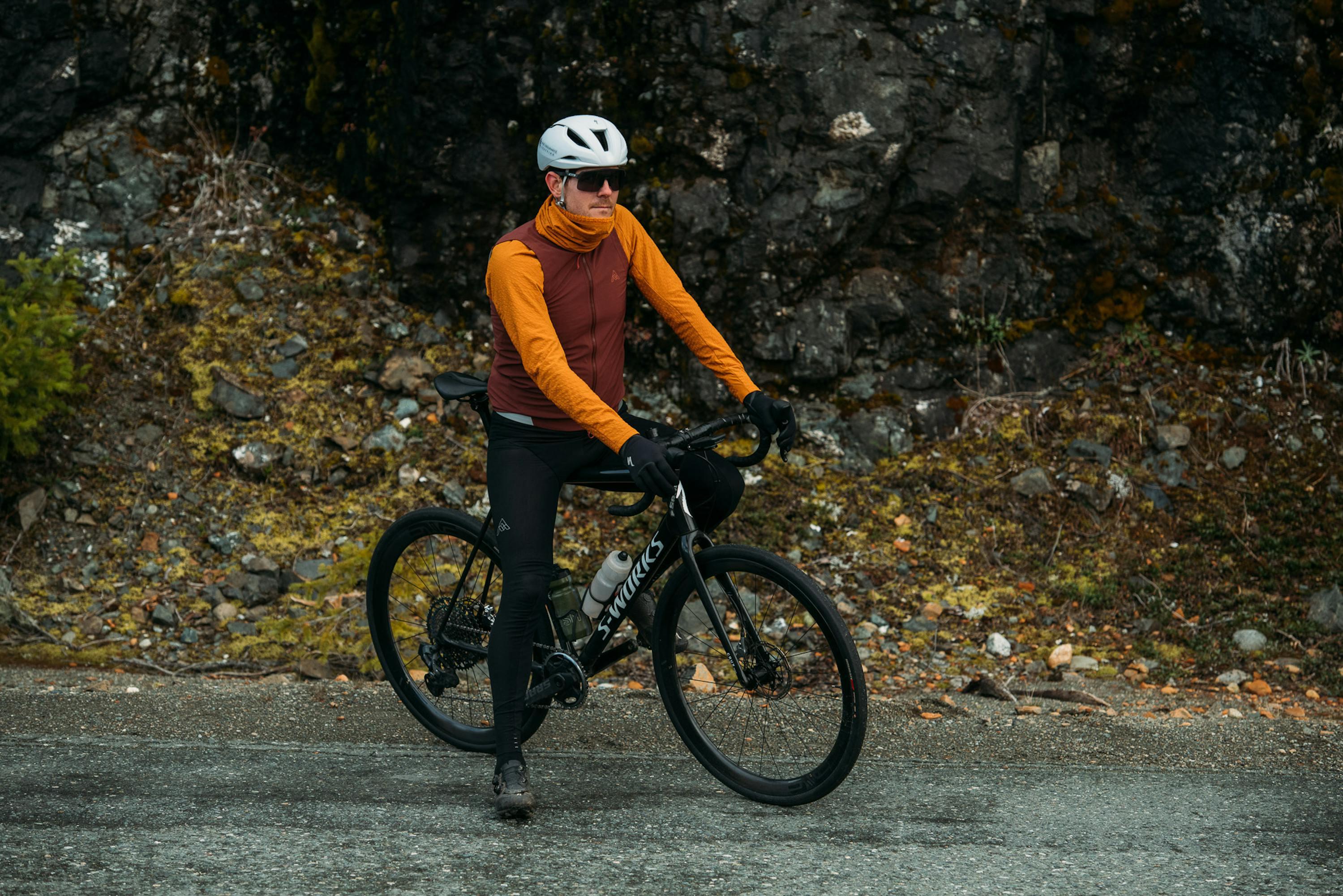 Man wearing a helmet and glasses on a road bike.