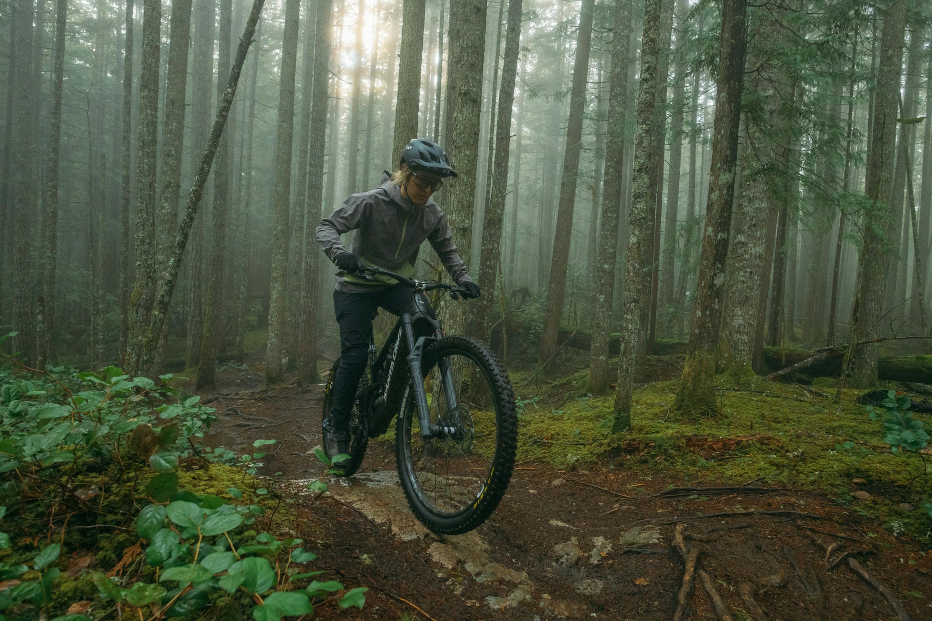 Woman riding a bike in the forest.