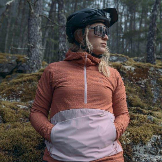 Woman wearing a pink jacket and a bike helmet